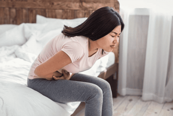 Woman holding her lower back from fibroid-related pelvic pressure, Southern California Vascular Institute, Los Angeles